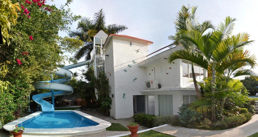 a house with a slide next to a swimming pool at Quinta Celeste in Temixco