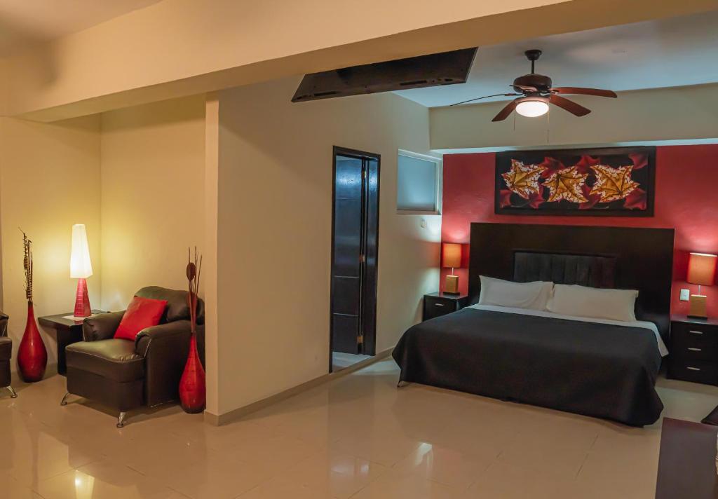 a bedroom with a bed and a couch and a fan at HOTEL ZAPOTLAN in Ciudad Guzmán