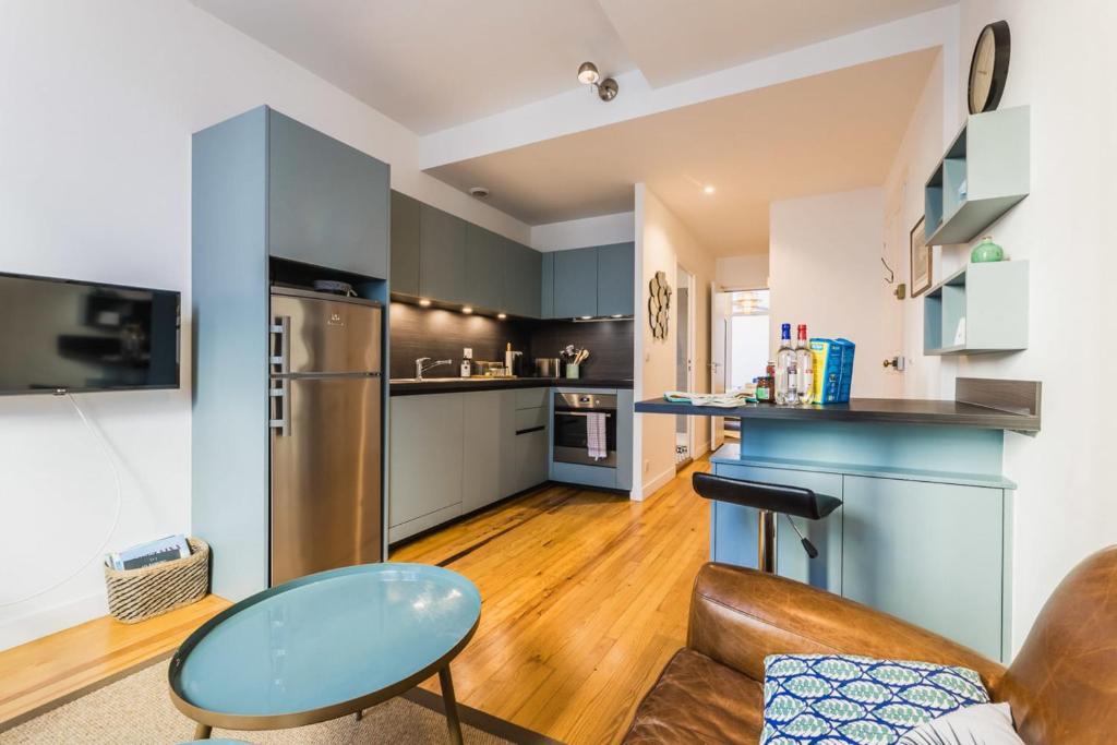 een keuken en een woonkamer met een bank en een tafel bij MAITALEA KEYWEEK Quiet downtown apartment in Biarritz