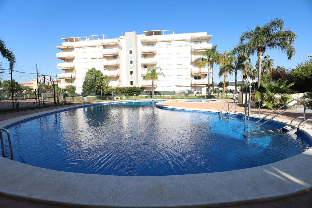 een groot zwembad voor een gebouw bij Ático con piscina en excelente urbanización by Hometels in Canet de Berenguer