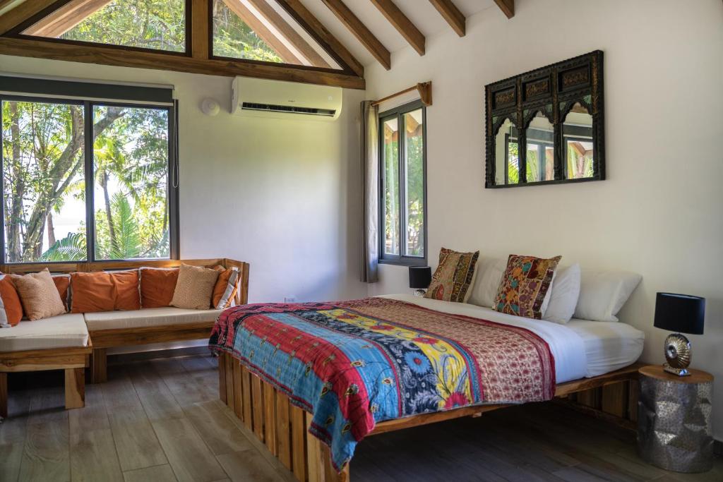 1 dormitorio con cama, sofá y ventanas en Catalina's Hideaway, en Santa Catalina