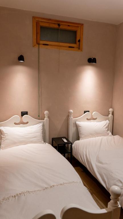two white beds sitting next to each other in a room at Bilocale a due passi dal mare immerso nel verde in Castiglioncello