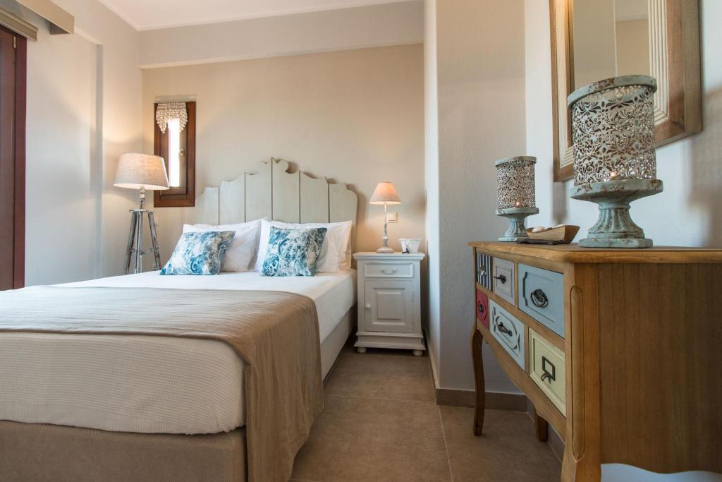 a bedroom with a bed and a dresser with a mirror at Blue Heart Luxury Suites II in Naxos Chora