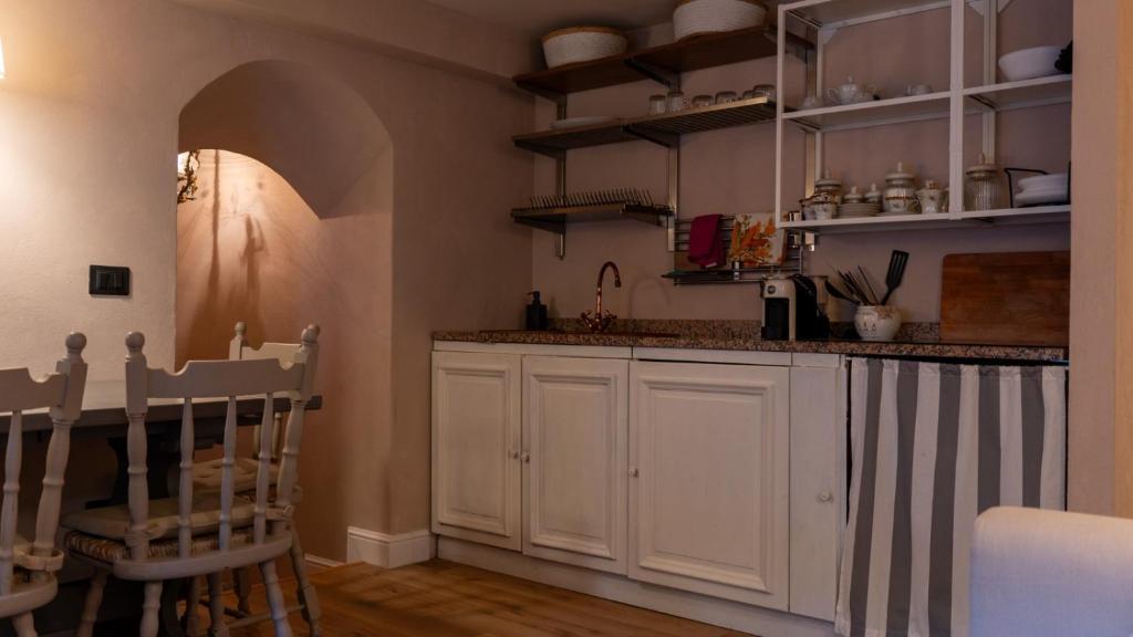 a kitchen with white cabinets and a counter top at Bilocale a due passi dal mare immerso nel verde in Castiglioncello