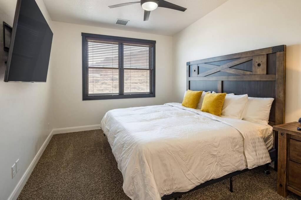 a bedroom with a large bed with yellow pillows at Luxury Downtown Rental - La Dolce Vita Villas #2 in Moab