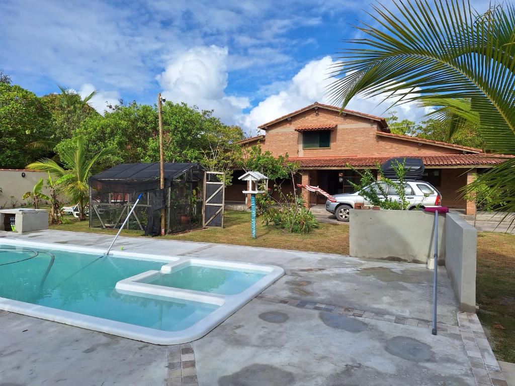 Costa Dourada的住宿－Casas lindas no paraiso!，一座带房子的庭院内的游泳池