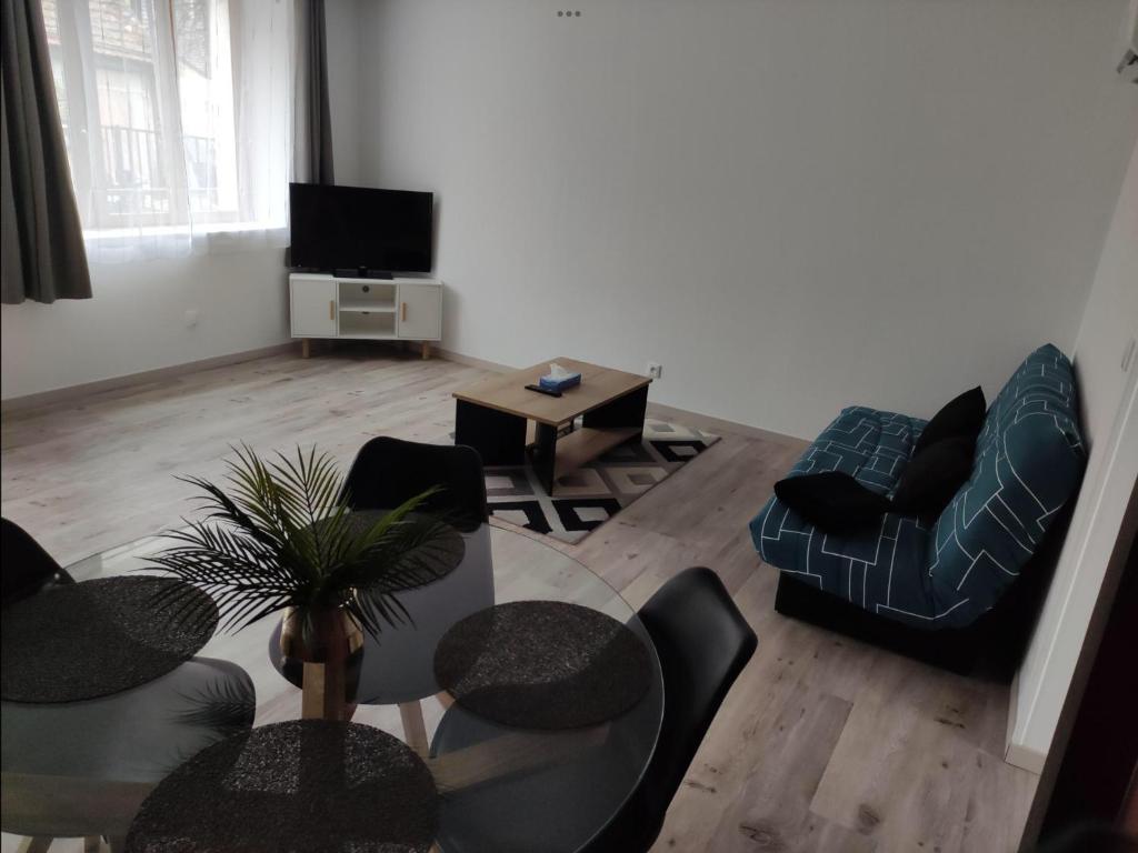 sala de estar con mesa, sillas y TV en Maison calme et chaleureuse, en Léré