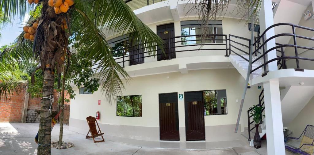 a building with a staircase and a palm tree at HOSTAL LOS NOGALES in Aguaytía