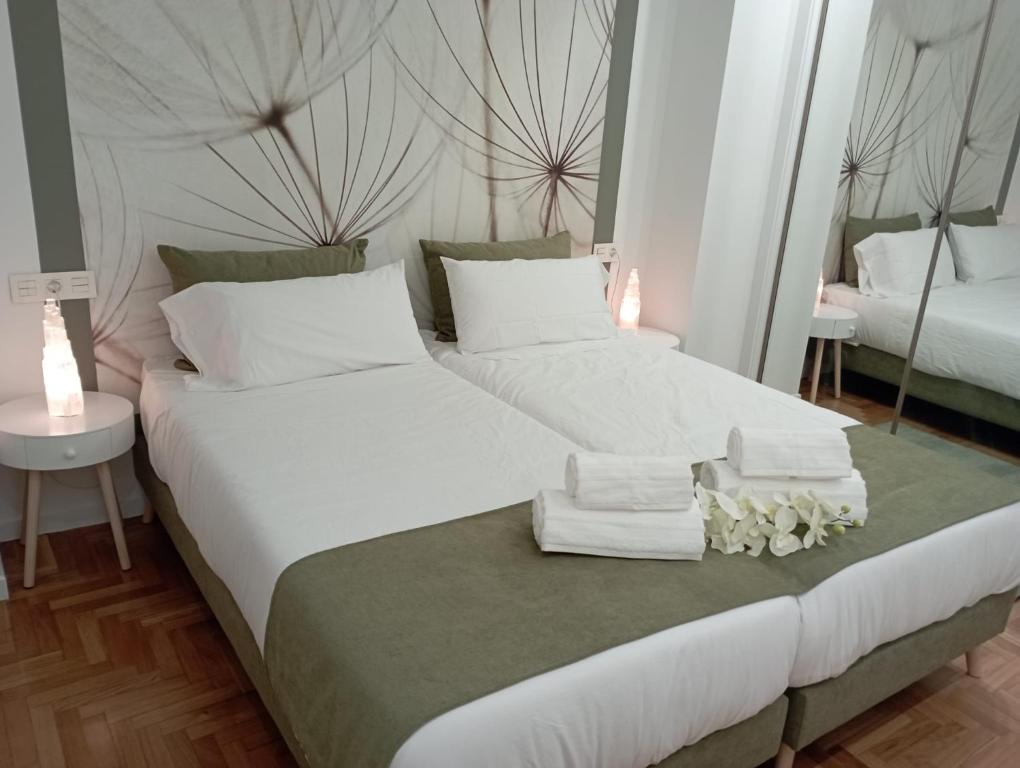 sypialnia z 2 łóżkami, ręcznikami i lustrem w obiekcie Súper apartamento Santiago w Santiago de Compostela