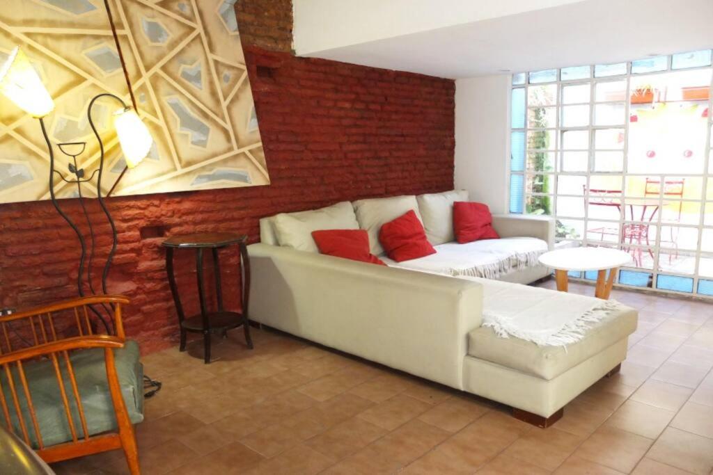 sala de estar con sofá blanco y almohadas rojas en Casa San Telmo 3026 en Buenos Aires