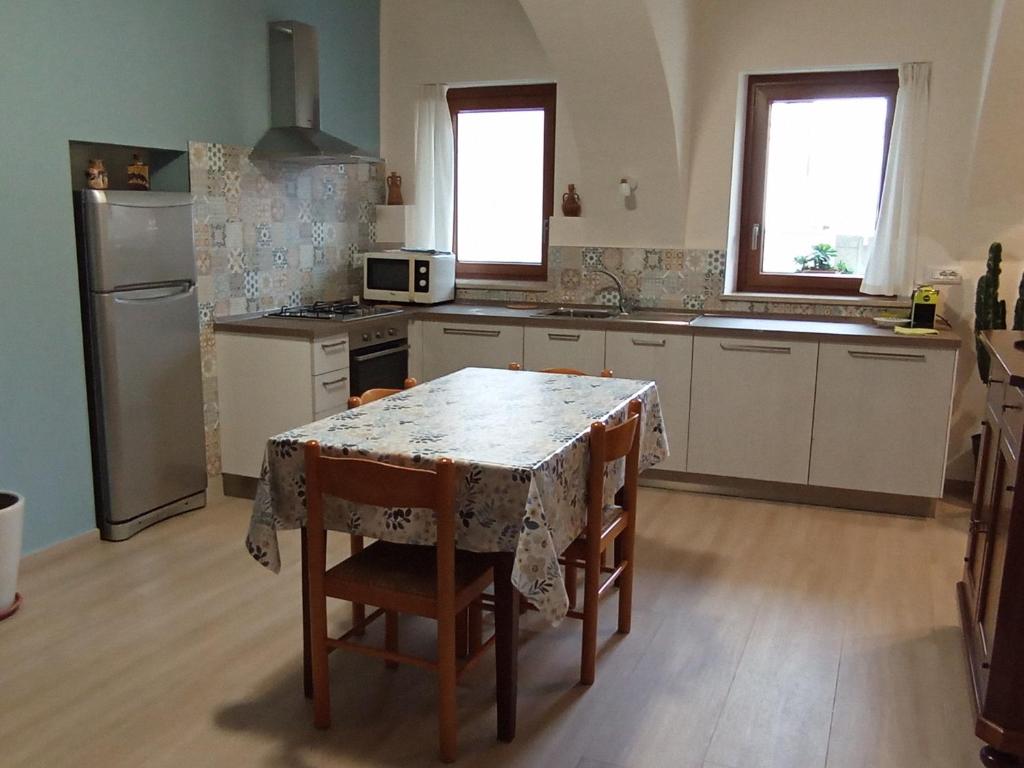 a kitchen with a table with chairs and a refrigerator at La Casa di Abe - Cuneo in Cuneo