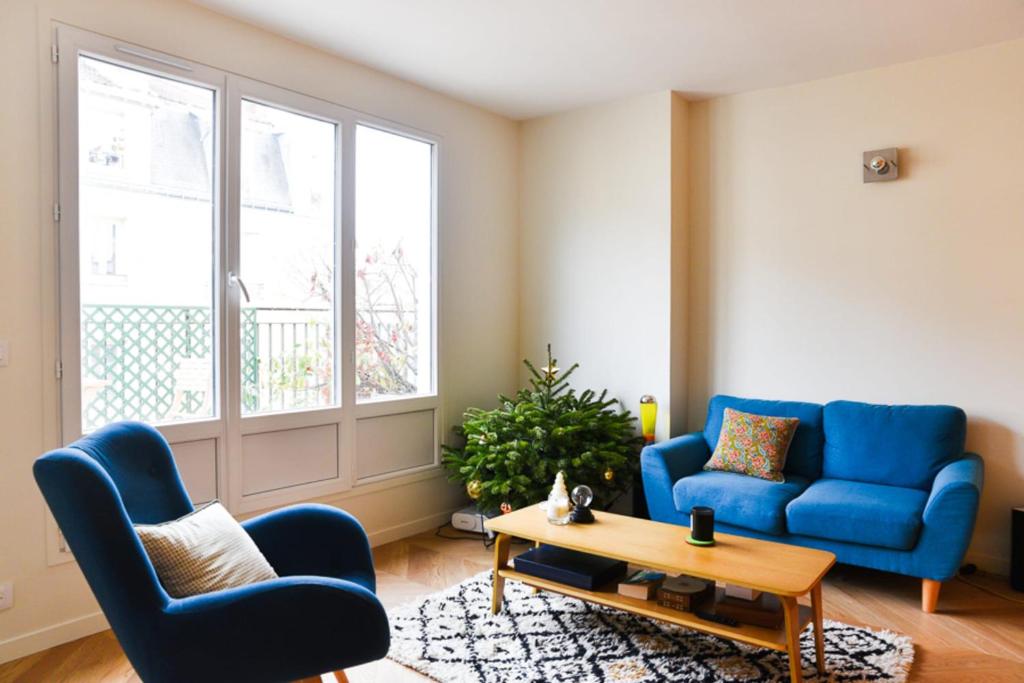 een woonkamer met twee blauwe stoelen en een salontafel bij 31 m fully renovated love nest in Boulogne-Billancourt