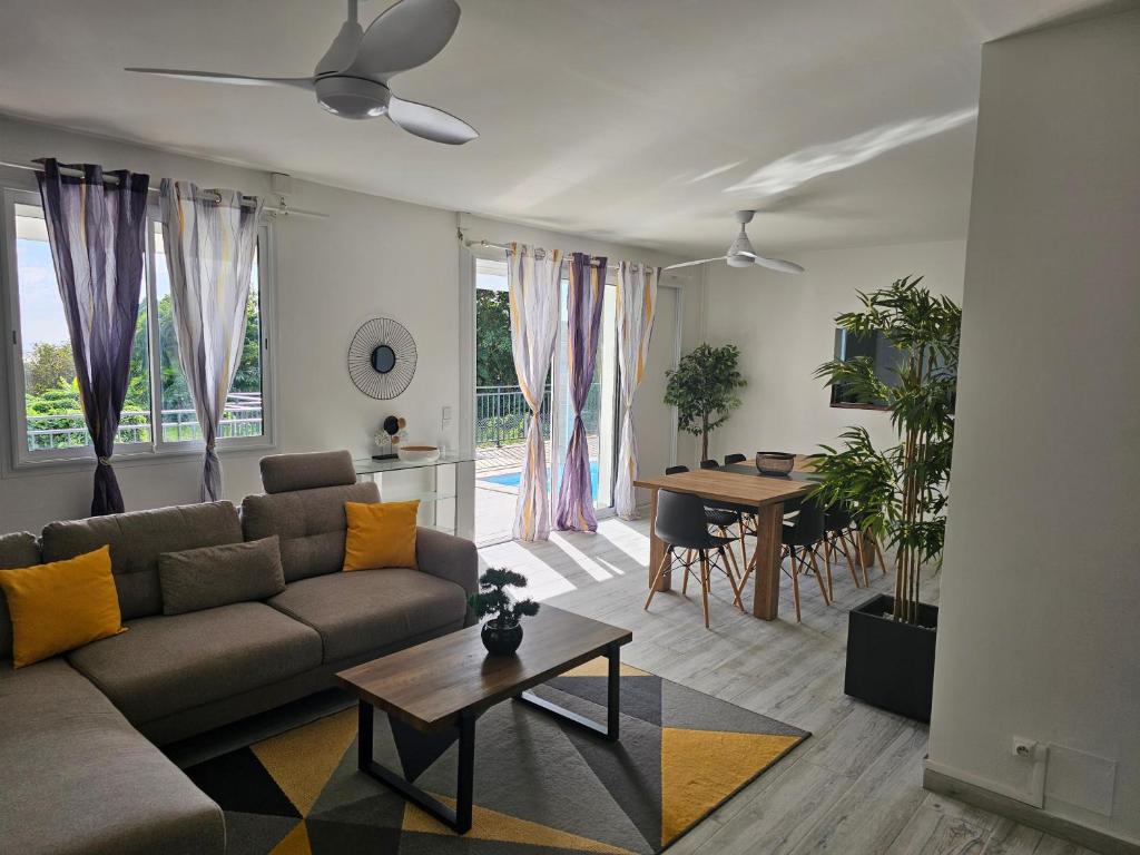 een woonkamer met een bank en een tafel bij Villa du marquis avec piscine in Capesterre-Belle-Eau