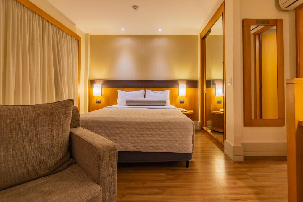 um quarto de hotel com uma cama e um sofá em Flat Executive Transamerica Faria Lima Itaim em São Paulo