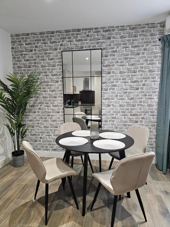 a dining room with tables and chairs and a brick wall at KORZO SUITES SLIEMA I in Sliema