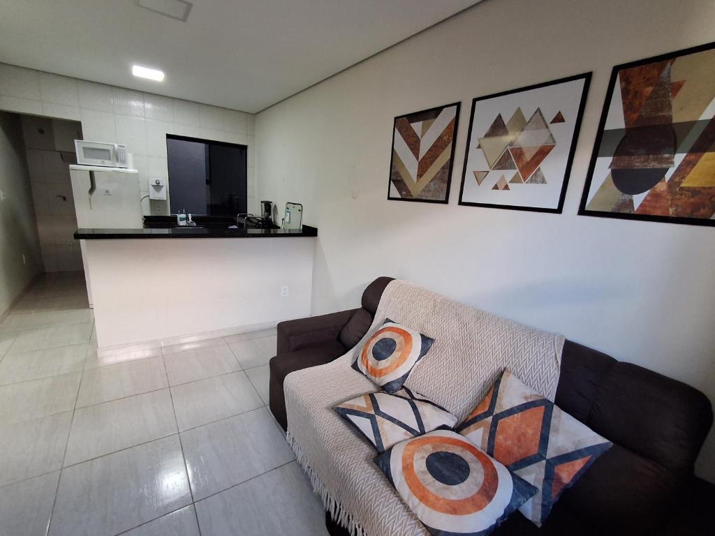 a living room with a couch and a kitchen at Ingá Hospedagem in Porto Velho