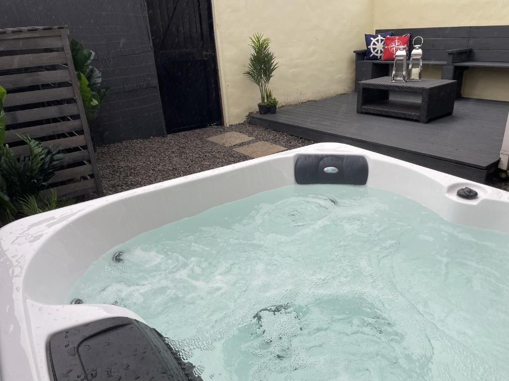 a jacuzzi tub in a yard with at Château by the Sea - Luxury hotel style 3 bed with hot tub in Newbiggin-by-the-Sea