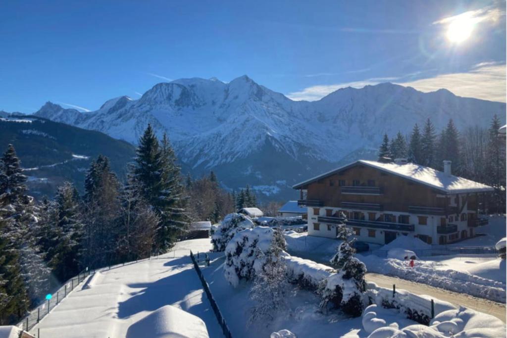 a house in the snow with mountains in the background at Ski nest - Pool - Mont Blanc view in Saint-Gervais-les-Bains