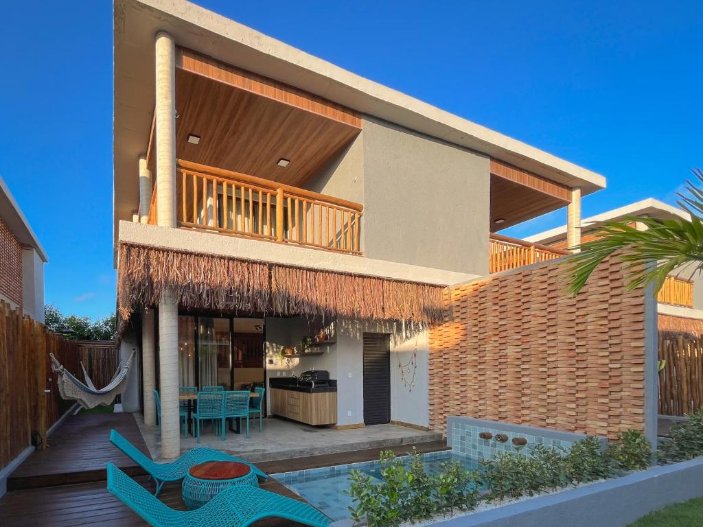 a house with a deck and a patio at Villa Sapê 9 in São Miguel dos Milagres