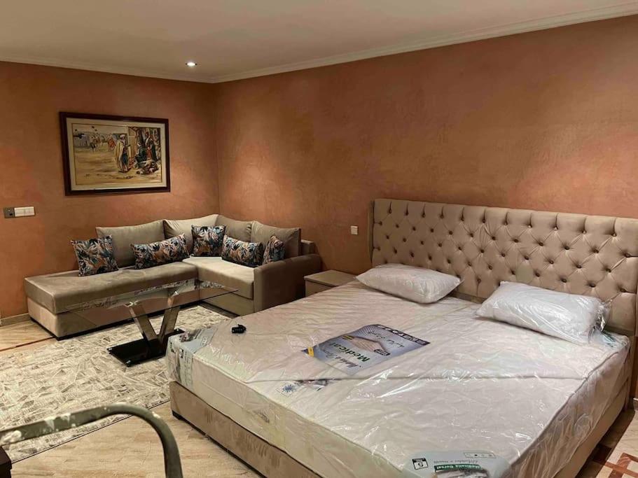 a bedroom with a large bed and a couch at Suite présidentielle avec jacuzzi in Rabat