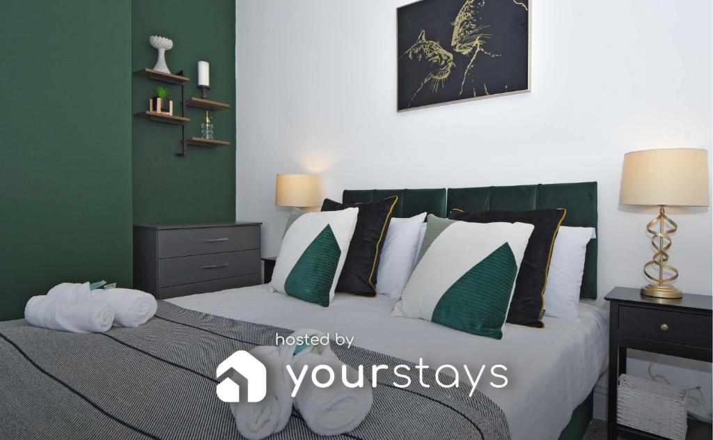 a bedroom with a bed with green and white pillows at Emerald Terrace by YourStays in Stoke on Trent