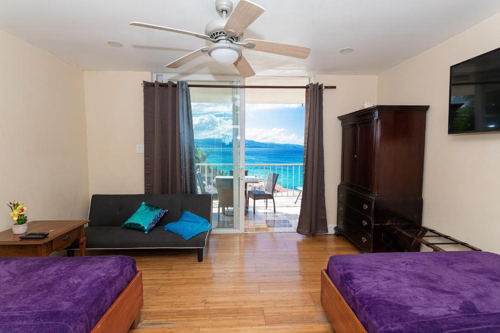 un soggiorno con divano e ventilatore a soffitto di Montego Bay Club Apartments a Montego Bay