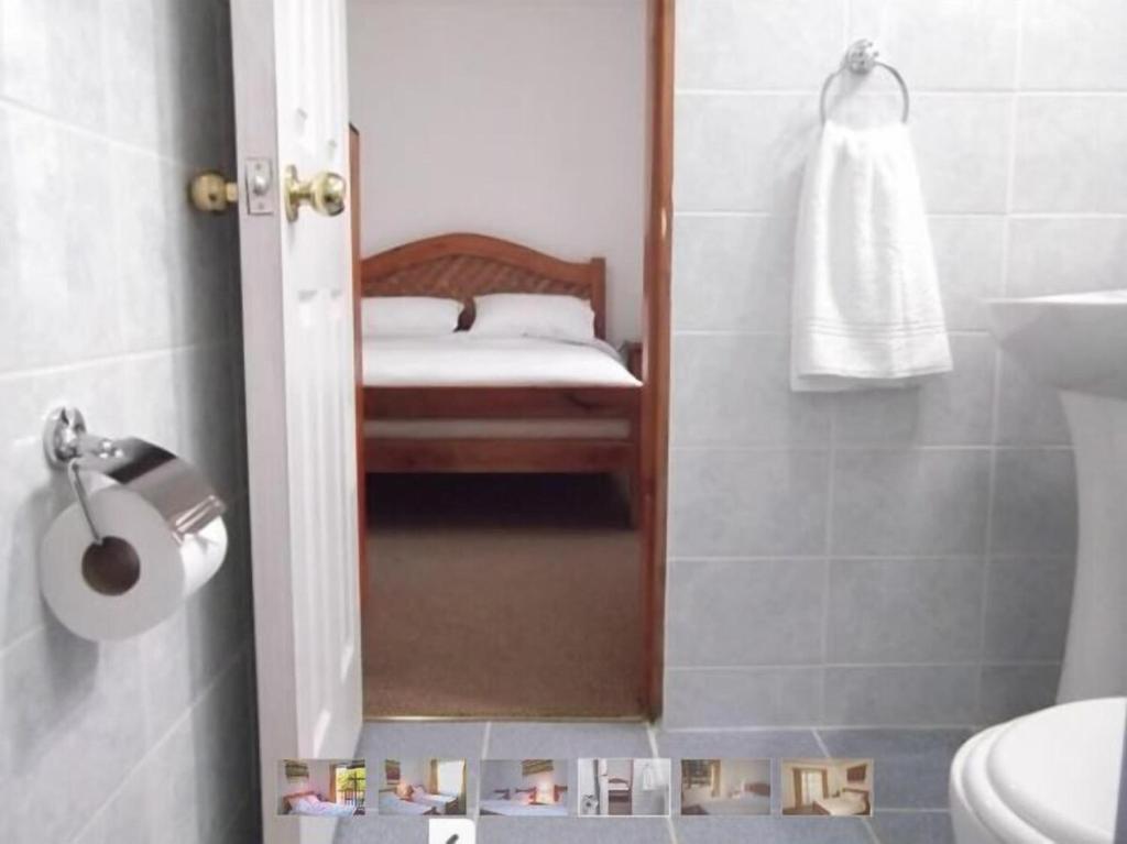 ein Bad mit einer Dusche, einem Spiegel und einem Waschbecken in der Unterkunft HOTEL MAUCHO PUCON in Pucón