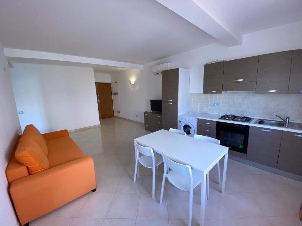 een woonkamer met een bank en een tafel en een keuken bij Estrela do Mar in Santa Maria
