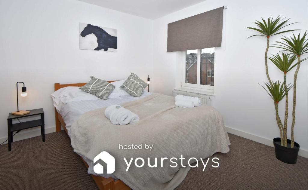 a bedroom with a bed with towels on it at Tansey House by YourStays in Newcastle under Lyme