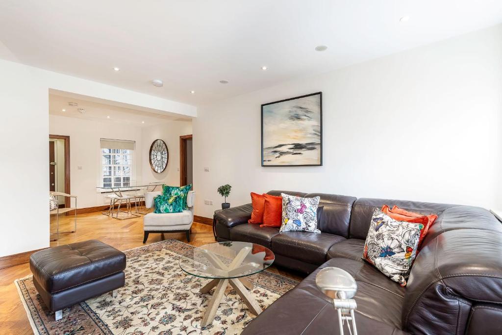 uma sala de estar com um sofá de couro e uma mesa em Colourful South Kensington Home em Londres