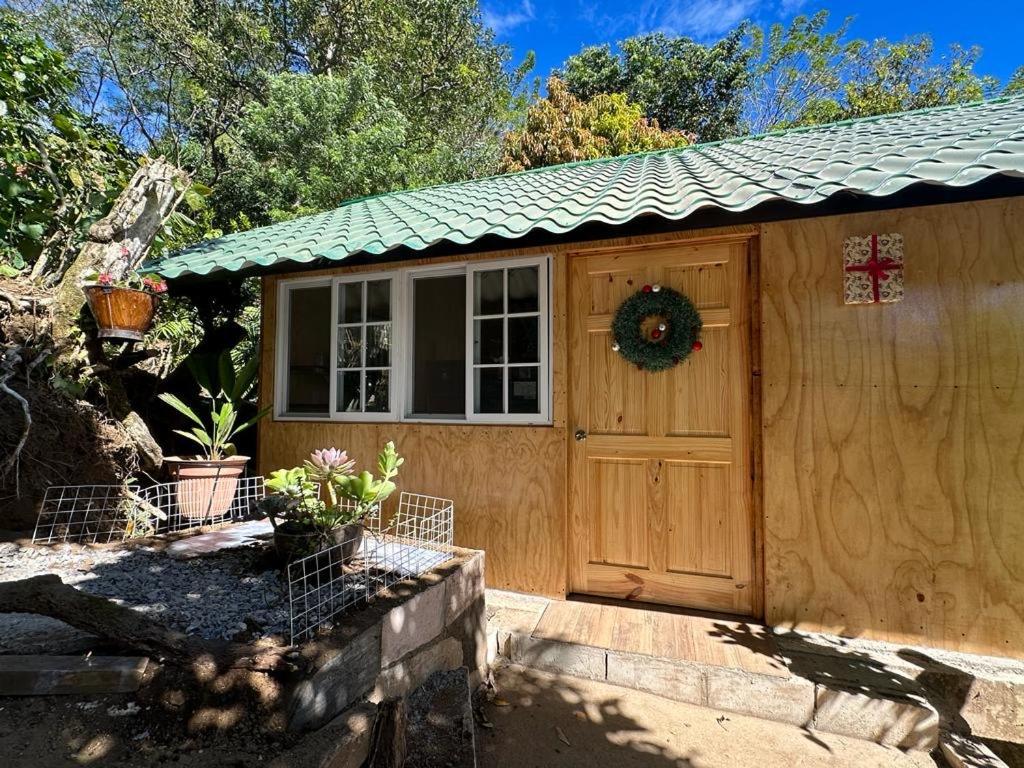 un garaje de madera con una corona en la puerta en Bonita cabaña estilo glamping en Juayúa