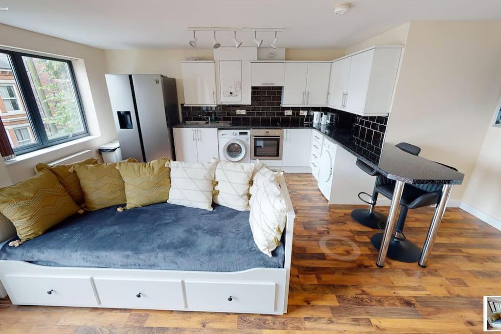 諾丁漢的住宿－Lovely two bed flat with free parking (4 117)，一间带白色沙发的客厅和一间厨房