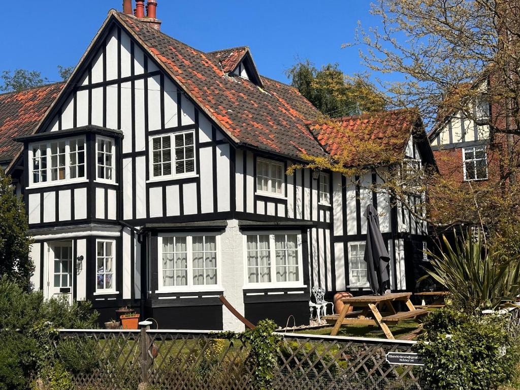 a black and white house with a roof at 6 The Whinlands in Leiston