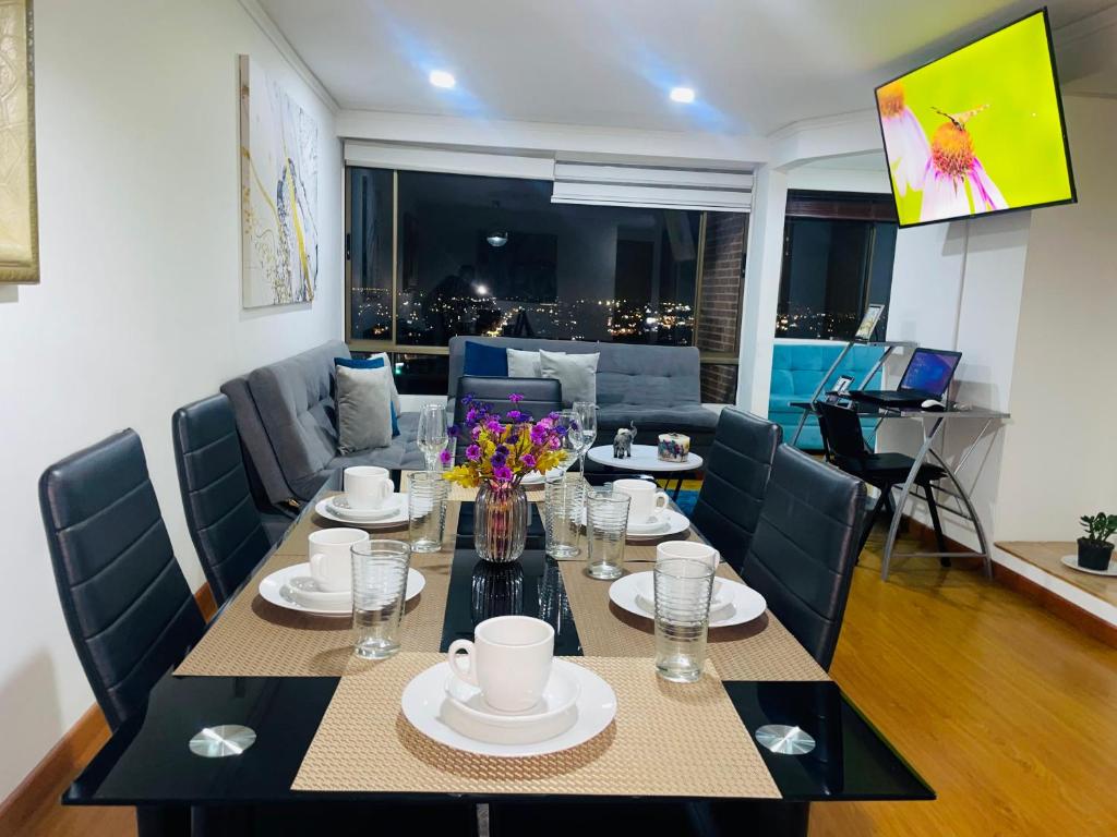 een eetkamer met een tafel en stoelen en een bank bij Loft blue zona T in Bogota