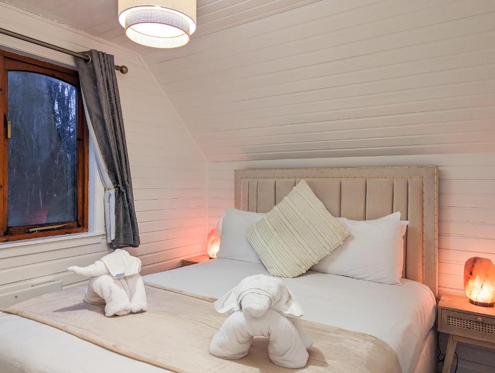 two stuffed animals are sitting on a bed at Boann 5 - Hot Tub-Hunting Tower Lodges-Luxury-Families-Romantic in Perth