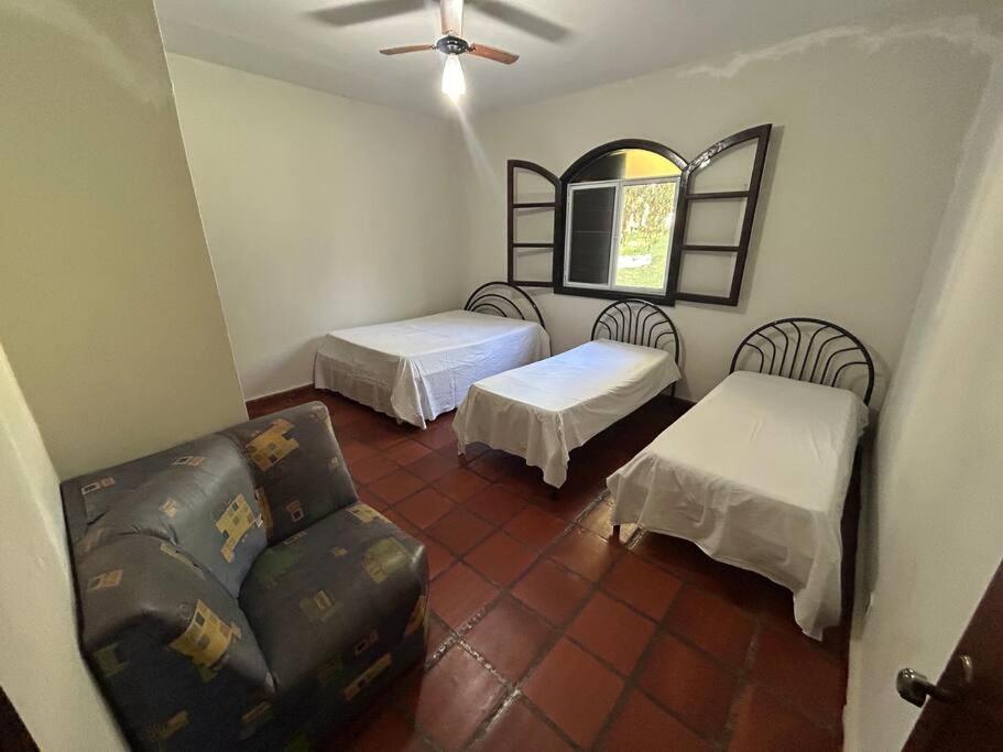 ein Wohnzimmer mit 2 Betten und einem Sofa in der Unterkunft Chácara Monteiro - Próximo ao Thermas Water Park in São Pedro