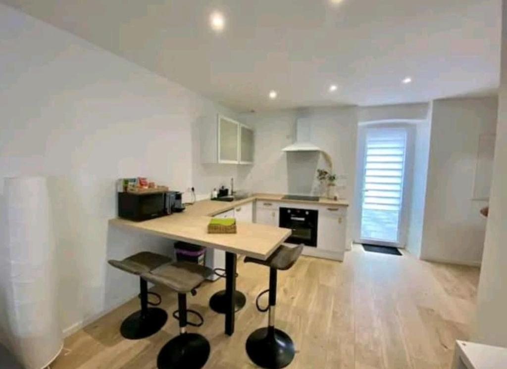 a kitchen with a table and chairs in a room at Maison de ville in Bouguenais