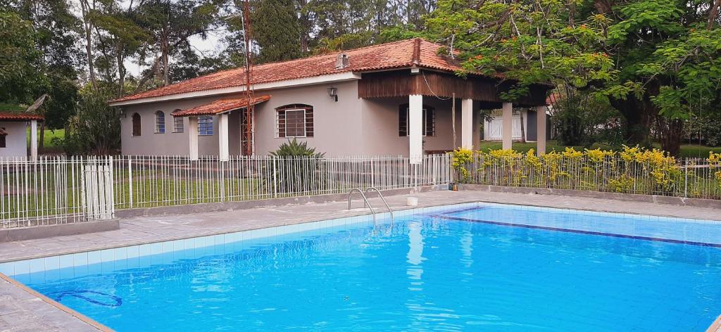a large blue swimming pool in front of a house at Chácara Monteiro - Próximo ao Thermas Water Park in São Pedro