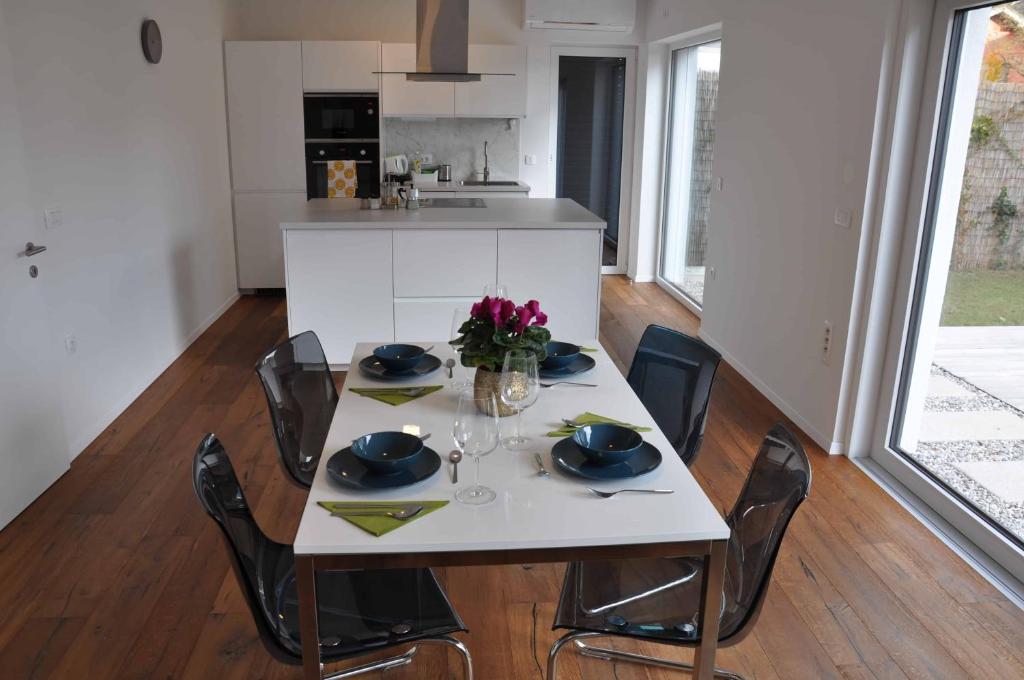a white table with chairs and a white kitchen at Apartments Trnovo in Ljubljana