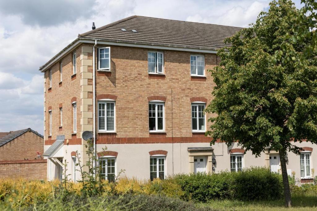 ein großes Backsteingebäude mit einem Baum davor in der Unterkunft Home near Rugby Station for contractors and Work Commuters, 5 bedroom, Free Parking & Garden 