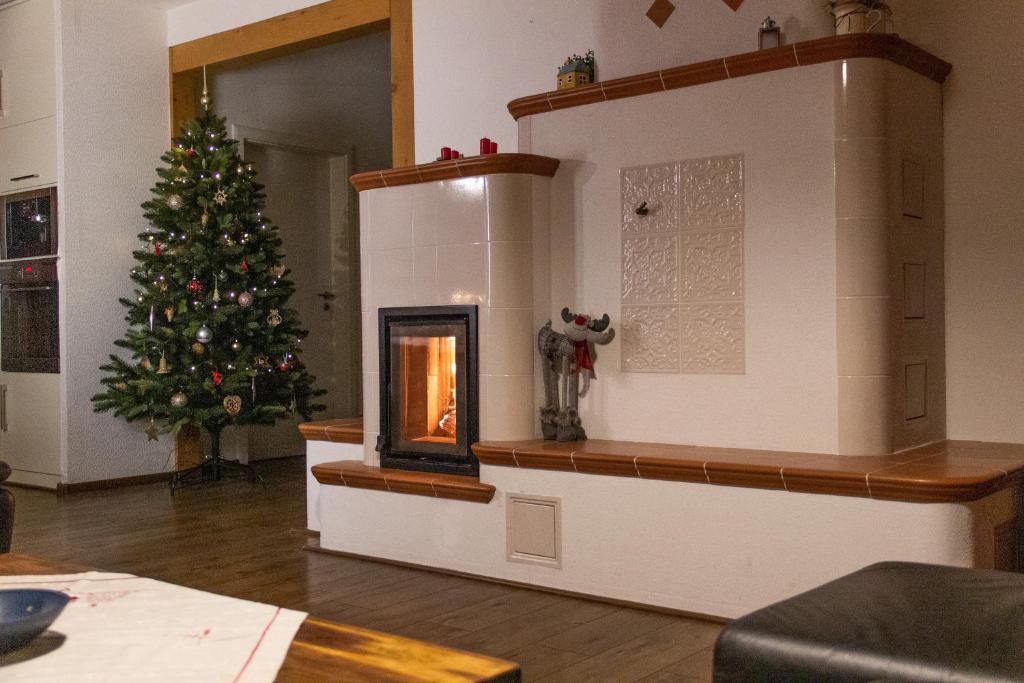 einen Weihnachtsbaum im Wohnzimmer mit Kamin in der Unterkunft Samostatný dom s bazénom v Rajeckej doline 
