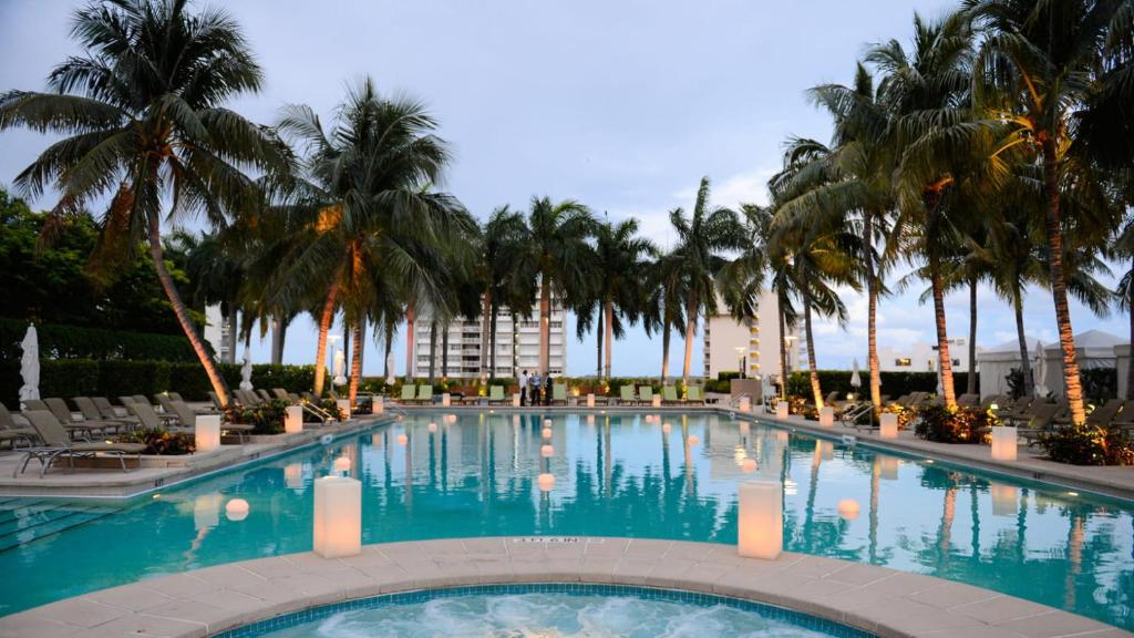 una gran piscina con palmeras y un edificio en LUXURY Condo at Four Seasons Brickell en Miami