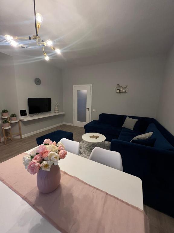 a living room with a blue couch and a vase with flowers at Central Gem Tirana in Tirana