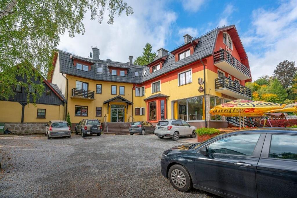 a large building with cars parked in front of it at Etna in Szklarska Poręba