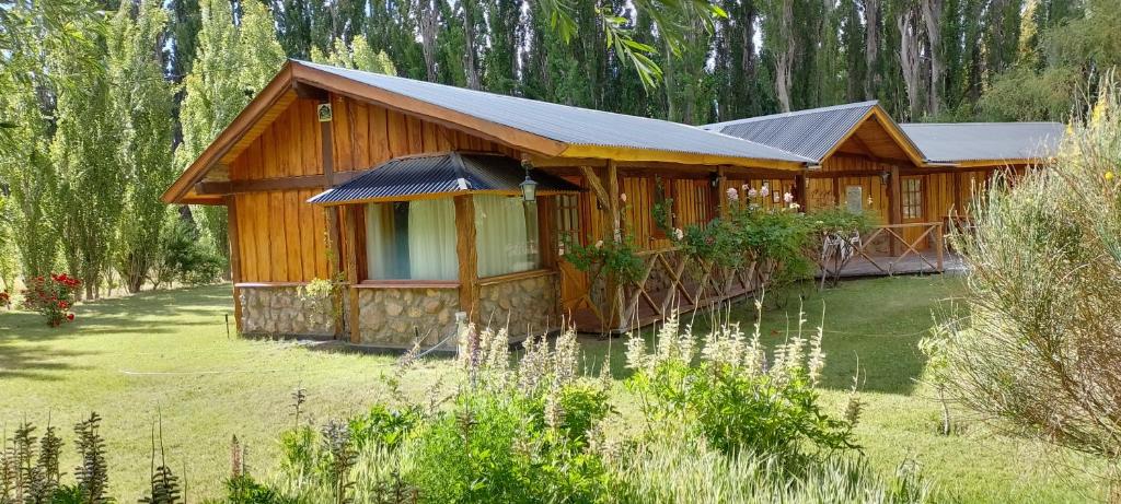 una cabaña de madera en medio de un campo de hierba en Chacra Kaiken Lodge en Perito Moreno