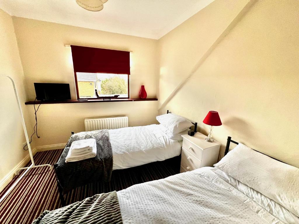 um quarto com 2 camas e uma janela em 50 Etherley Lane em Bishop Auckland