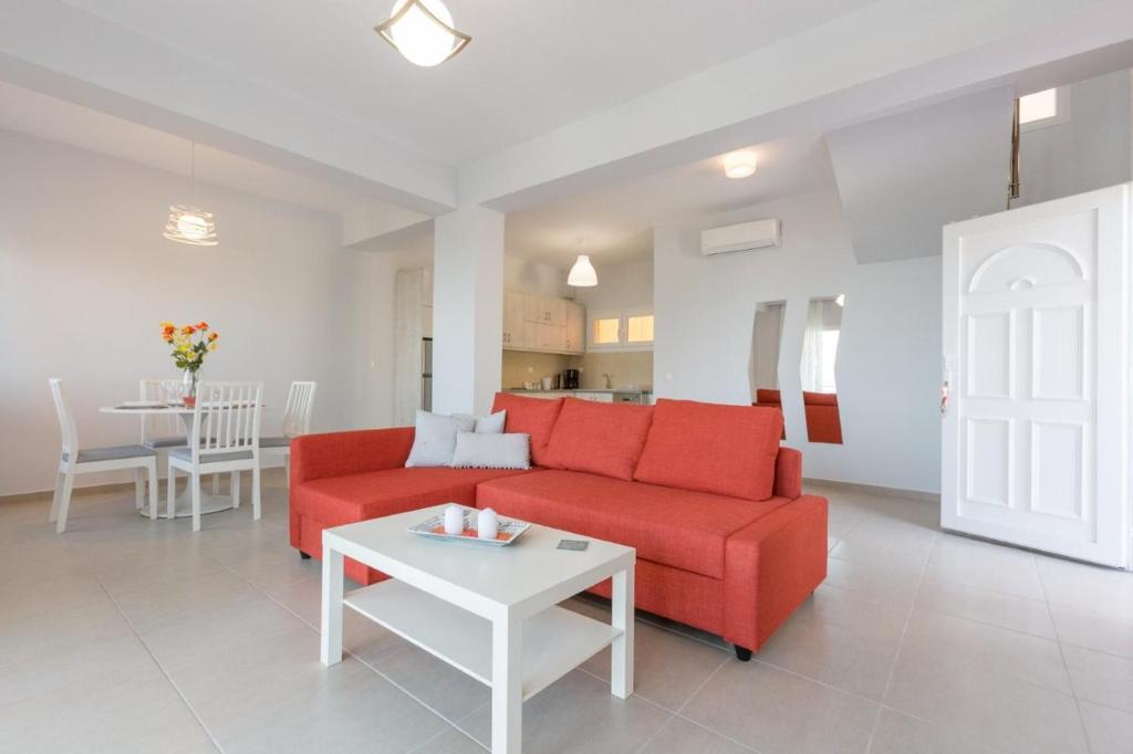 salon z czerwoną kanapą i stołem w obiekcie Corfu Sea View Villa - Eros w mieście Barbati