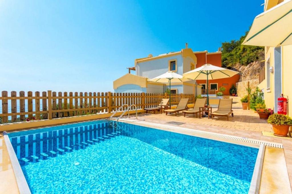 a swimming pool in front of a house at Corfu Sea View Villa - Sequoia in Barbati