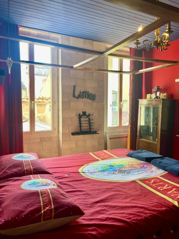 - une chambre avec un lit rouge et 2 oreillers dans l'établissement Harry Potter expérience, à Marseille