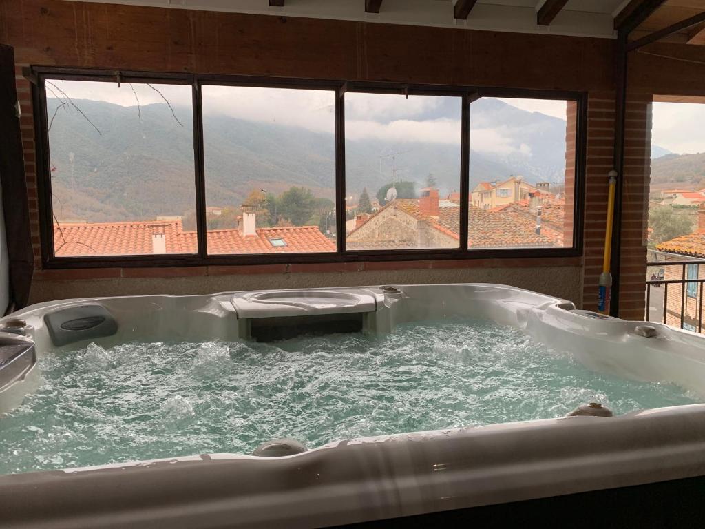 bañera en una habitación con ventana en Maison de caractère avec jacuzzi entre mer et montagne à Espira de Conflent en Espira-de-Conflent
